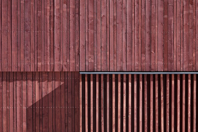 Das Holzöl auf Leinölbasis wurde zunächst als farblose Grundierung aufgetragen. Dann folgte die Schlussbeschichtung mit einer in bemerkenswertem Feuerwehrrot abgetönten Variante von Lignodur Xylodol 540, die die natürliche Holzstruktur weiter – ja, genau – anfeuert.