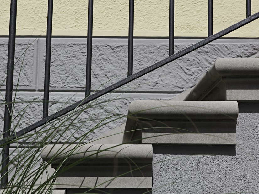 Detailaufnahme von einer Treppe und dem farblichen Übergang zwischen Sockel und Fassadenfläche.