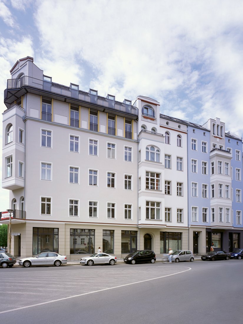 Das Eckgebäude ist in hellen, edlen Sandsteinfarbtönen gestaltet. Das Blau der anschließenden Fassade bildet dazu einen reizvollen Kontrast.