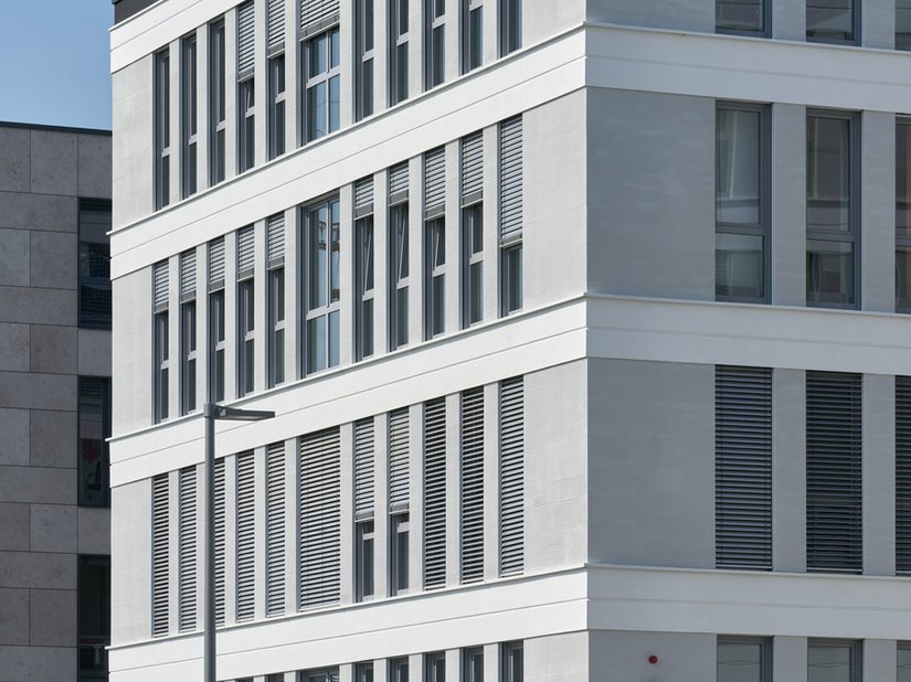 Der aufwendig in das Dämmsystem integrierte Sonnenschutz greift die konsequente horizontale Gliederung der Fassade auf und fügt sich so nahtlos in das Gestaltungskonzept ein.
