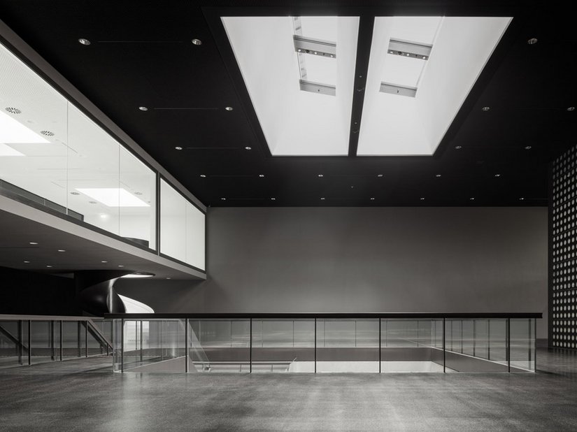 Die Ausstellungsflächen mit Raumhöhen von 6-11m sind geprägt durch dunkel eingefärbten Sichtbeton, schwarzen Gussasphaltboden und schwarze Metalldecken.