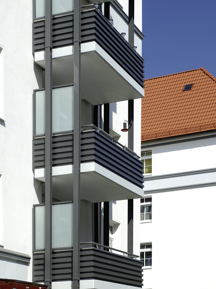Die neuen straßenseitigen Vorstellbalkone werten die Wohnqualität auf – und durch ihre gekonnte farbige Abstimmung auch das Fassadenbild.