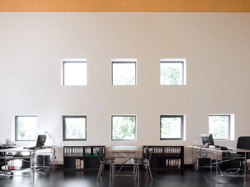 Die Nordgiebelseite von innen: Die acht quadratischen, geometrisch angeordneten neuen Fenster belichten den Büroraum.