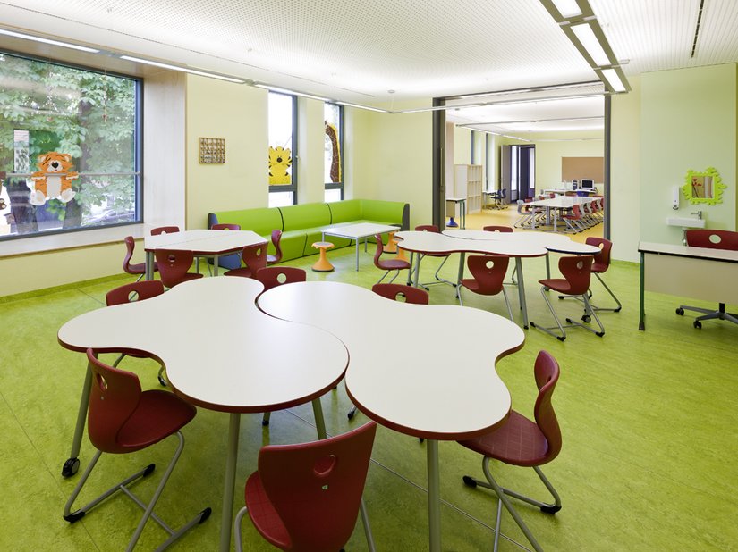 Die Klassen werden von kräftigen Grün- und Rottönen bestimmt. Die geometrische Form der Tische bietet hohe Flexibilität im Unterricht.