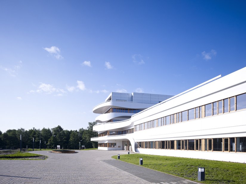 Die Gebäude für die Lagerhalle, das Zentrum für Kundenbetreuung und das Verwaltungsgebäude formen einen u-förmigen Komplex mit gestaffelten Gebäudehöhen.