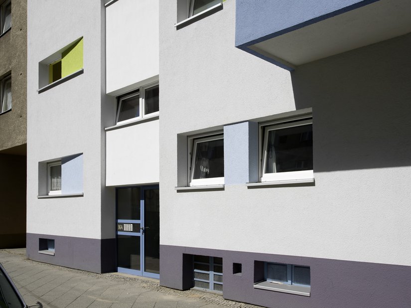 Das zurückspringende Treppenhaus erstrahlt in einem Weißton mit einer feineren Putzstruktur als die übrige Fassade.