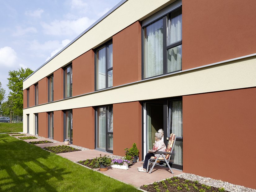 Die gewählten Erdfarben vermitteln Wärme und Geborgenheit. Der Rostton der Fensterspiegel harmoniert mit den roten Terrassensteinen und dem Grün der Wiese.