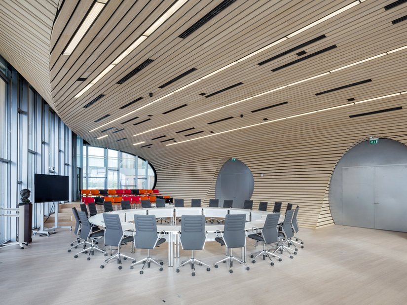 Runde Formen und geschwungene Linien, kombiniert mit natürlichen Materialien wie Holz und viel Glas, charakterisieren die Innenraumgestaltung.