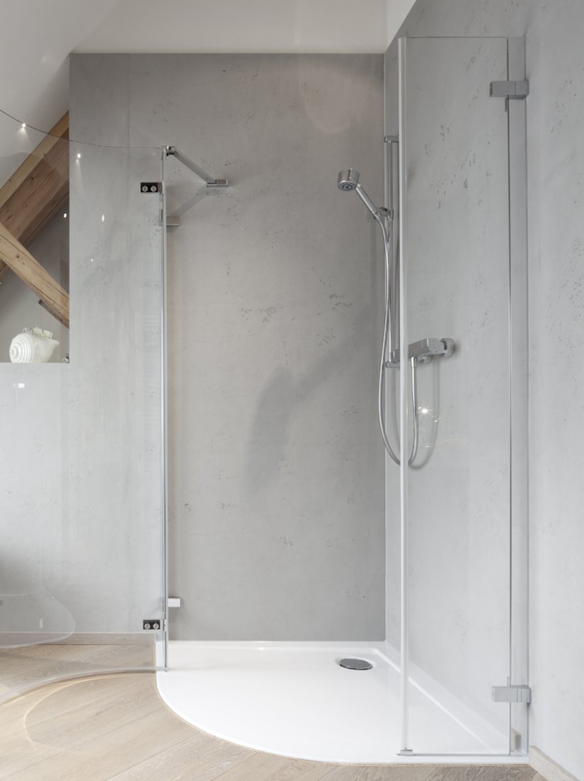 Die Dusche mit Glaswänden passt sich dem modernen Stil der Wohnung an.