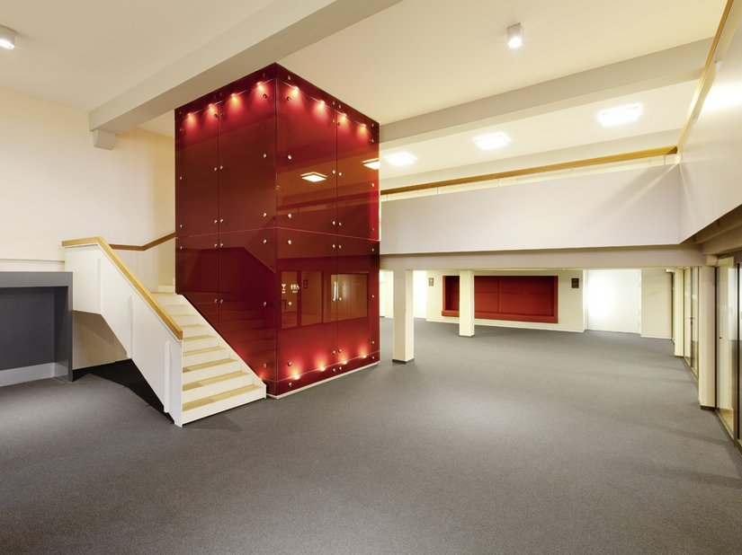 Neue Stahltreppen und ein rot verkleideter Aufzug führen zu den Seminarräumen im ersten und zweiten Geschoss.