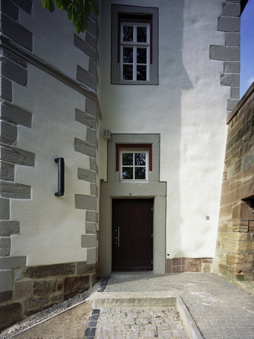 Für reizvolle Akzente sorgen die innerhalb der Fenstergewände (09.06.12) tieferliegenden Profilierungen und Abphasungen, die in einem zu Violett tendierenden Rotton (30.12.24) gefasst sind. Die Fenstergewände wurden zur Fassadenfläche hin zusätzlich mit einem Begleitstrich/Ritzer im Farbton 63.03.18 abgesetzt.