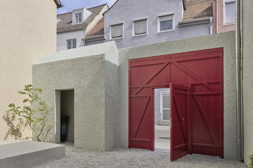 Das markant rote Hoftor mit integrierter Schlupftür setzt ein selbstbewusstes Statement im Innenhof. Auch das Müllhäuschen wurde mit Objektcharakter in die Fassade integriert. Beschichtet wurden die Putzflächen mit der mineralischen Außendispersion Ultrasil 1901. Die Holzbauteile erhielten ein Finish mit Lignodur Solvo Guard 885.