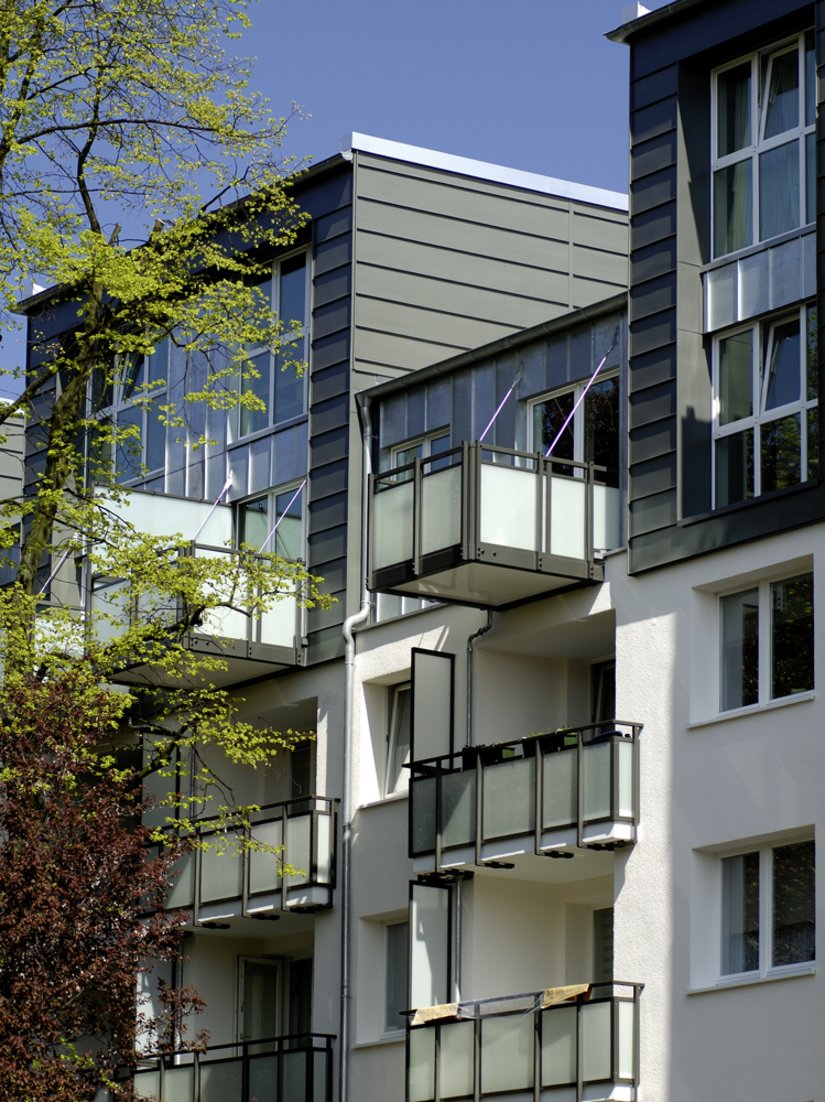 Die dezenten Farbtöne der erneuerten Fassade gehen mit dem warmen Rot der Spaltklinker-Flächen an den Kopfbauten einen sehenswerten Dialog ein. Die keramischen Beläge sorgen außerdem für eine Integration in das Stadtbild.