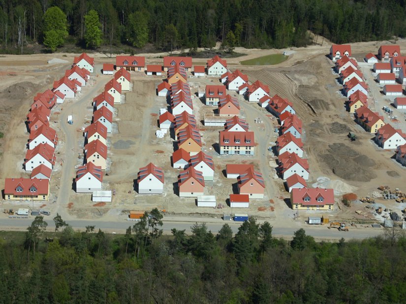 Auf dem Luftbild der bereits fertiggestellten östlichen Bauabschnitte zeigt sich die belebende Farbtonvielfalt der Fassaden.