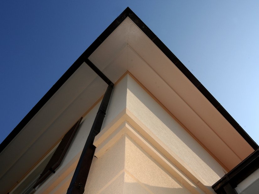 Die Fassadenstruktur durch glatt verputzte und an der Fassade leicht vorspringende Profile und Bänder setzt sich bis zur Dachuntersicht fort.