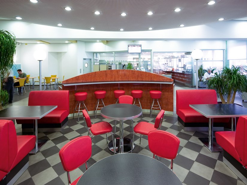 Noch einmal Betriebsrestaurant Halle 1 Nord: Sie ist in unterschiedliche Farb- und Erlebnisbereiche zoniert. Diese Gliederung spiegelt sich in Bestuhlung, Innenarchitektur und auch der Fußbodengestaltung wider.