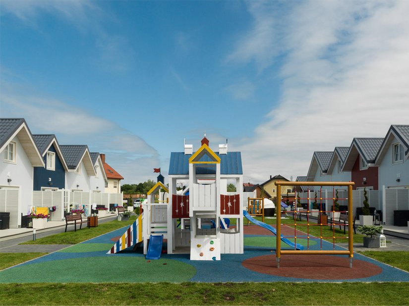 Der Spielplatz dient zwischen den Holzhäusern als Freizeitbereich.
