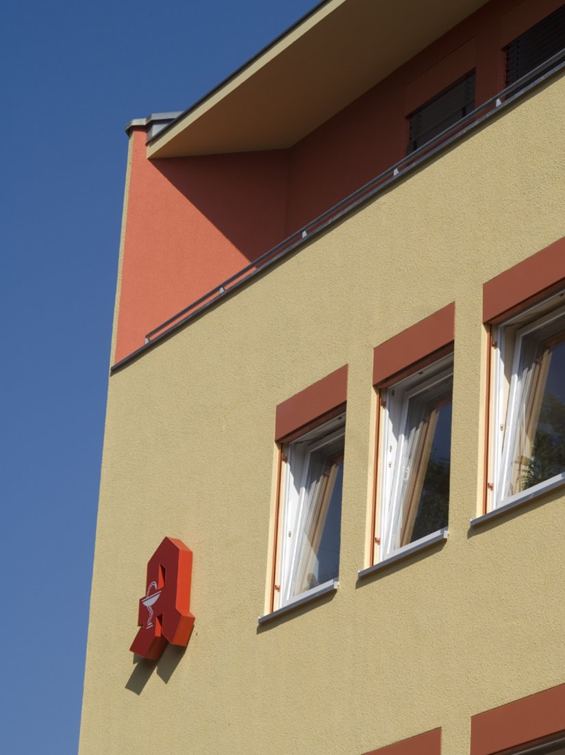 Detail Jalousienkästen und Staffelgeschoss: Die Jalousienkästen sind im roten Fassadenton gefasst. Scala Farbtöne: Fassade: 12.12.09, Fassade EG, Staffelgeschoss, Treppenhaus: 27.15.21